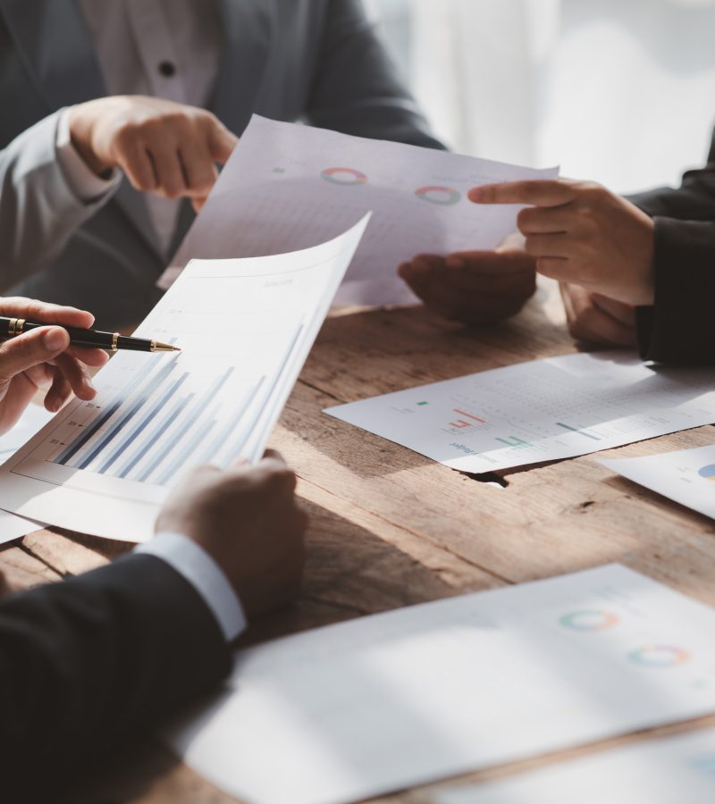 Businessman is reviewing monthly sales documents for analysis and marketing plans for more sales growth, they are the founders of young companies co-founding startups. Sales management concept.